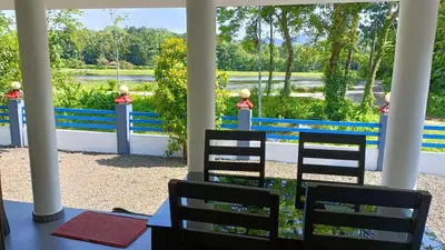 a porch with chairs and a view of a lake at Jewel Homes Thattekad For birding and families - An ISO9001 ISO14001 ISO22000 Certified in Thattakād