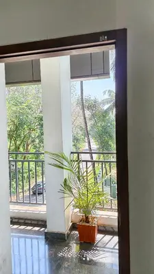 a plant in a pot sitting in front of a window at Nelleri Residency Managed By Vaishno Hospitality in Iritti