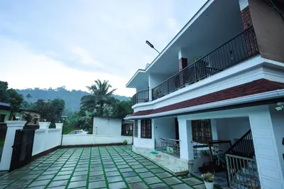 a courtyard of a house with a balcony at Wayanadan Huts Homestay in Sultan Bathery