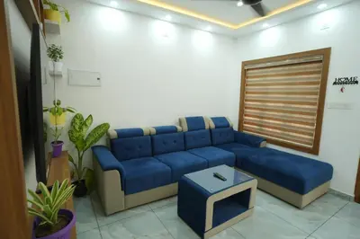 a living room with a blue couch and a table at Wayanadan Huts Homestay in Sultan Bathery