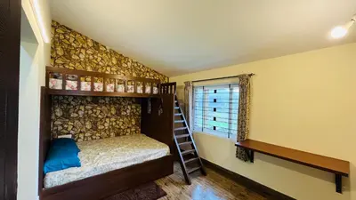 a room with a bunk bed and a ladder at Away From Home - 7 - Home Stay Ooty, Entire 3BHK Villa in Ooty