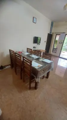 a dining room with a table and wooden chairs at Blue Hills View in Attappādi