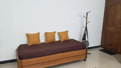 a bed with four pillows on it in a room at Cliff view in Ooty