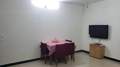 a table with chairs and a television in a room at Cliff view in Ooty