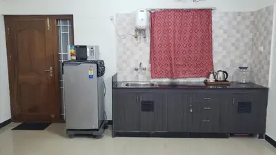 a small kitchen with a refrigerator and a sink at Cliff view in Ooty