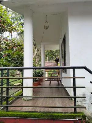 a porch of a house with a wooden deck at coorg Namana homestay in Suntikoppa