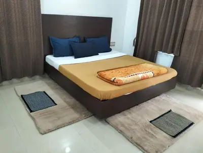 a bed in a room with two rugs at coorg Namana homestay in Suntikoppa