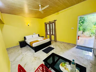 a yellow room with a bed and a tv at Himadri Retreat Wayanad in Kaniyāmbetta