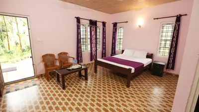 a bedroom with a bed and a table and chairs at Himadri Retreat Wayanad in Kaniyāmbetta