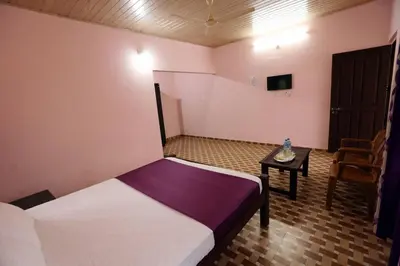 a small bedroom with a bed and a table at Himadri Retreat Wayanad in Kaniyāmbetta
