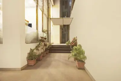 a hallway with potted plants and stairs in a building at Townhouse Oak Mysuru Railway Museum in Mysore