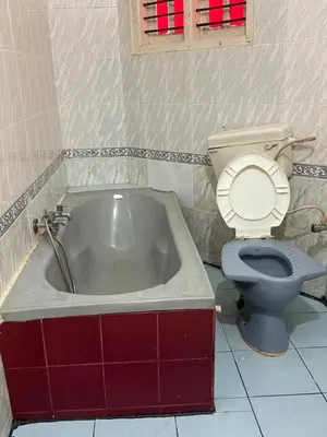 a bathroom with a bath tub and a toilet at City home-SGH in Mysore