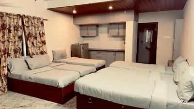 a room with three beds and a kitchen at City home-SGH in Mysore
