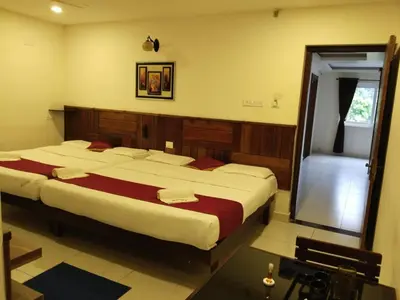a bedroom with two beds and a mirror at sree ganesh inn in Palani