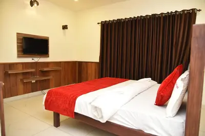 a bedroom with a bed with a red blanket at sree ganesh inn in Palani