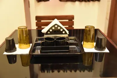 a table with a tray with two glasses on it at sree ganesh inn in Palani