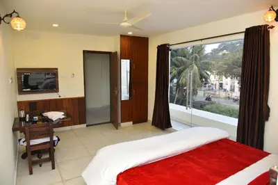 a bedroom with a bed and a large window at sree ganesh inn in Palani