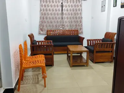 a living room with a couch and chairs and a table at shambhala homestay in Ooty