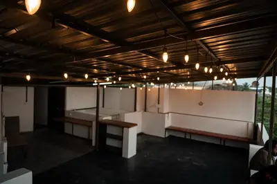 a large room with benches and lights on the ceiling at Beach House in Kozhikode