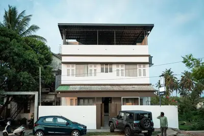 a man and a car parked in front of a building at Beach House in Kozhikode