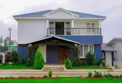 a blue and white house with a balcony at Maria villa in Ooty