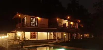 a house with a pool in front of it at night at Enchanted Woods in Perumbavoor