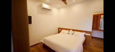 a bedroom with a bed with white sheets and pillows at Enchanted Woods in Perumbavoor