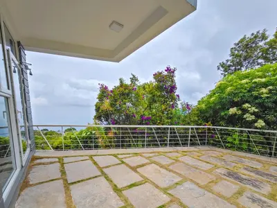 an open balcony with a view of the ocean at Ibex Resorts, Coonoor - Tapas in Yedapalli