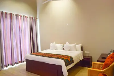 a bedroom with a bed with white sheets and curtains at Ibex Resorts, Coonoor - Tapas in Yedapalli