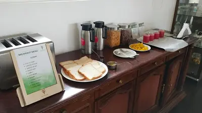 a kitchen counter with bread on a plate next to a microwave at Ibex Resorts, Coonoor - Tapas in Yedapalli