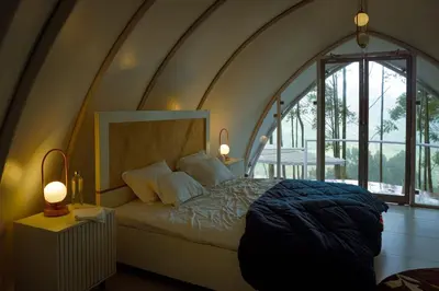 a bedroom with a large bed with a large window at Cocoon-coxcargill in Vattavada