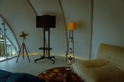 a living room with a couch and a clock on the wall at Cocoon-coxcargill in Vattavada