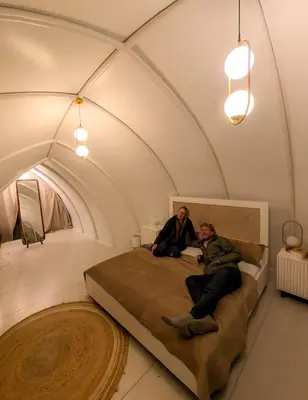 two people sitting on a bed in a room at Cocoon-coxcargill in Vattavada
