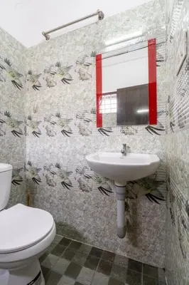 a bathroom with a toilet and a sink at Holiday Homes Aluva in Alwaye