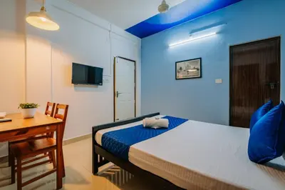 a bedroom with a bed and a desk and a television at Holiday Homes Aluva in Alwaye
