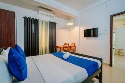 a bedroom with a bed with blue pillows and a television at Holiday Homes Aluva in Alwaye