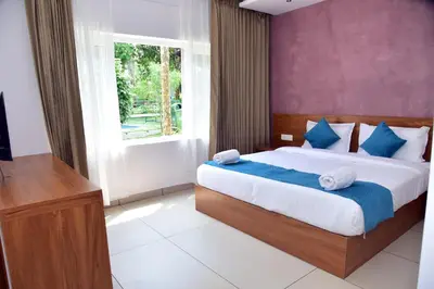 a bedroom with a large bed and a window at Snow White Wayanad in Wayanad
