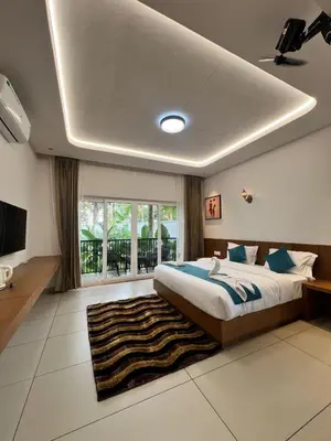 a bedroom with a large bed and a large window at Snow White Wayanad in Wayanad
