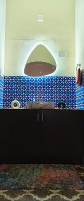 a bathroom with a sink and a large window at Maryland homestay in Thattakād