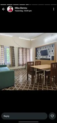 a living room with a table and chairs and a tv at Maryland homestay in Thattakād
