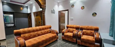 two brown leather chairs in a room at Premium Service apartment in Mysore