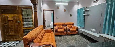 a living room with a couch and chairs in it at Premium Service apartment in Mysore