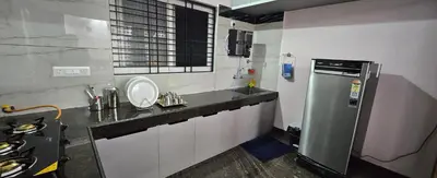a small kitchen with a sink and a refrigerator at Premium Service apartment in Mysore