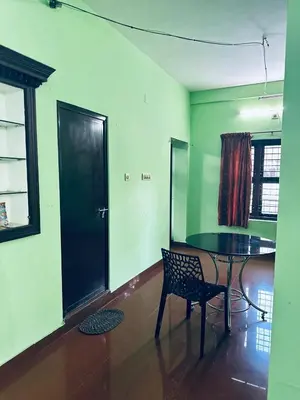 a dining room with a table and a chair at EV7 Stays in Trichūr