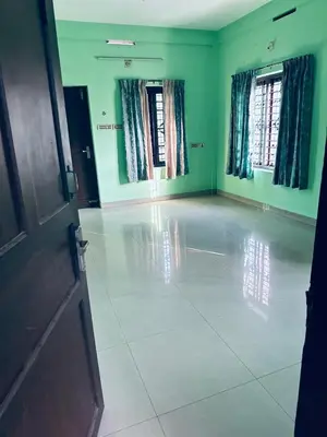 an empty room with green walls and a white tile floor at EV7 Stays in Trichūr