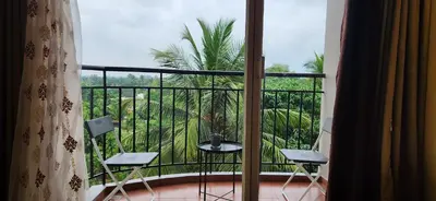 a balcony with a view of a palm tree at 2BR Flat with Pool and Balcony near Cochin Airport in Cochin