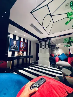 a person holding a remote control in a room at 2BR Flat with Pool and Balcony near Cochin Airport in Cochin