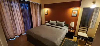 a small bedroom with a bed and a window at 2BR Flat with Pool and Balcony near Cochin Airport in Cochin