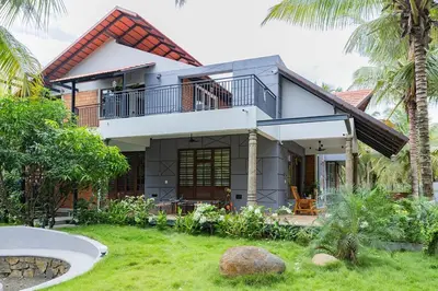 a house with a balcony and a yard at Ekta Pool Farmstay Pollachi in Pollāchi