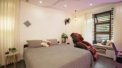 a bedroom with a large bed and two chairs at Ekta Pool Farmstay Pollachi in Pollāchi